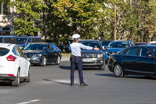 Police agent, Romanian Traffic Police (Politia Rutiera) directing traffic. Rush hour in Bucharest, Romania, 2022