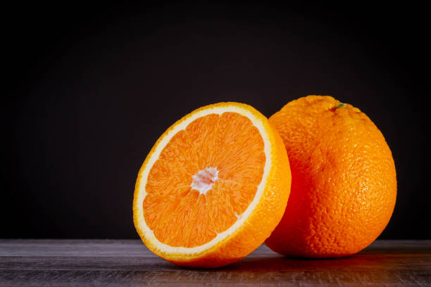 istock Half an orange. Two halves of fruit on a wooden table. Copyspace. 1483349718