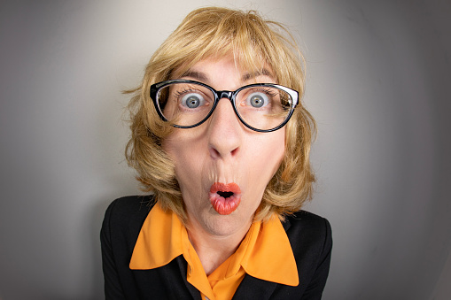 A funny fisheye image of an older woman making a surprised expression.