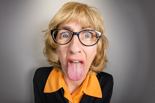 A funny fisheye image of an older woman sticking her tongue out in disgust.