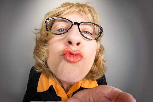 A funny fisheye image of an older woman puckering up for a kiss.