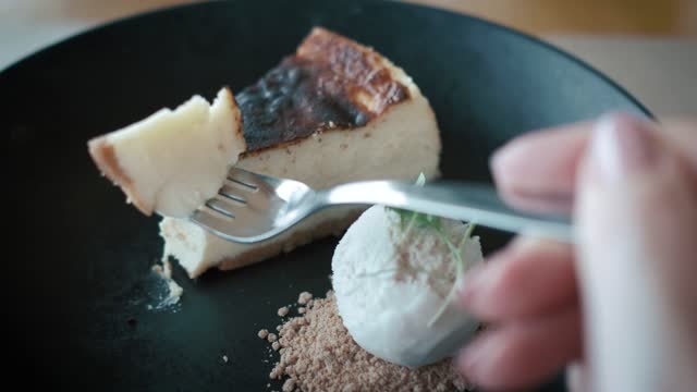 Taking a slice of a cheesecake with a fork.