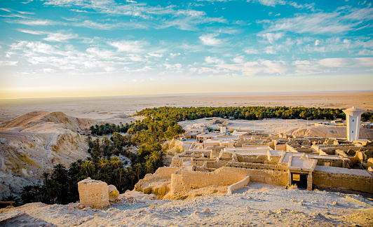 A charming view of an ancient city overlooking an oasis and sunrise