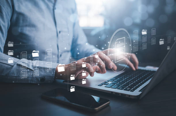 istock E-signing, electronic signature, document management concept, Man working on laptops with Online documentation database, searching and managing corporate files, documentation in enterprise with ERP. 1483358189