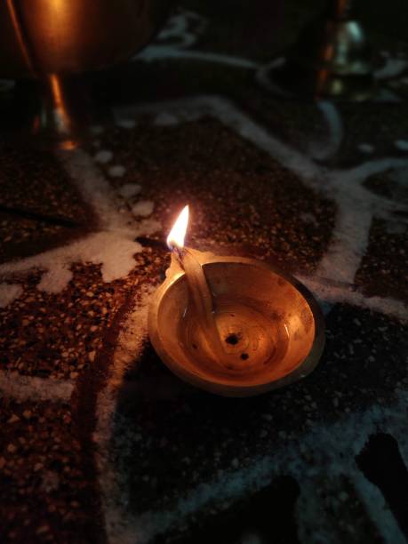 istock Burning oil candle with a yellow flame radiating light, providing a source of illumination 1483359129