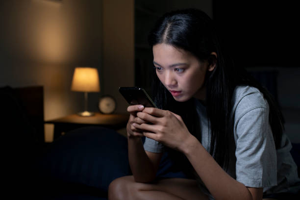 istock Exhausted young Asian woman using smartphone late at night. 1483361666