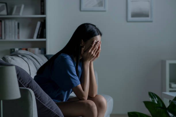 người phụ nữ trẻ châu á ngồi trên ghế sofa ở nhà cảm thấy buồn, mệt mỏi và lo lắng, bị trầm cảm về sức khỏe tâm thần. - stress hình ảnh sẵn có, bức ảnh & hình ảnh trả phí bản quyền một lần