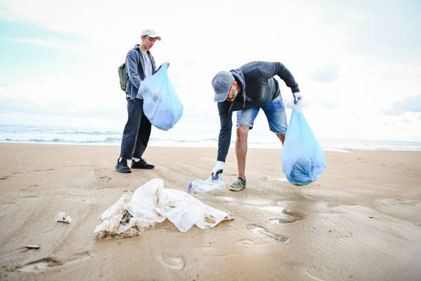istock father and son cleans up the beach 1483362047