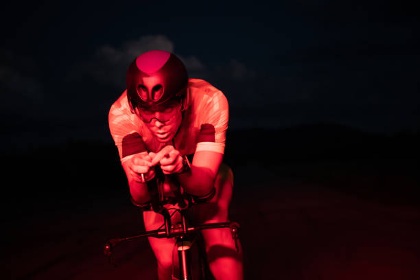 A triathlete rides his bike in the darkness of night, pushing himself to prepare for a marathon. The contrast between the darkness and the light of his bike creates a sense of drama and highlights the athlete's determination and perseverance un triatleta monta su bicicleta en la oscuridad de la noche, esforzándose para prepararse para un maratón. el contraste entre la oscuridad y la luz de su bicicleta crea una sensación de drama y resalta la determinación y perseverancia del atleta.