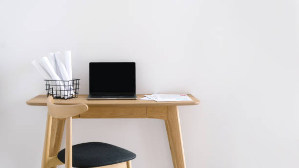 istock wooden desk with netbook on white background, workplace concept 1483366645