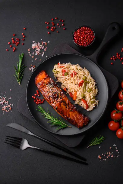 Photo of Delicious red salmon fish grilled with sauce and sesame seeds with rice and vegetables