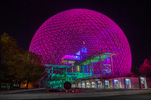 The Montreal biosphere is lit by a system of rotating projectors. Colors change slowly during the night. For the duration of the Covid 19 pandemic Montreal decided to change the colors to that of the rainbow. Parc Jean Drapeau, Île Ste-Hélène, Montreal.