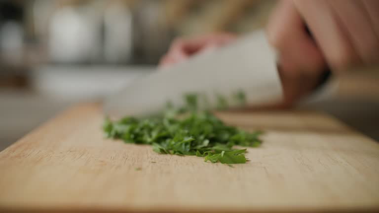 chopping parsley on wooden chopping board