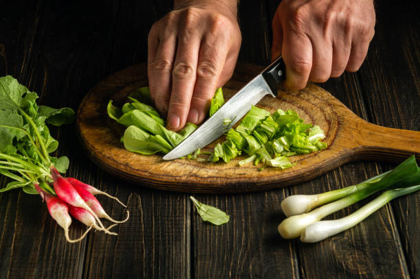 faça salada de alface e rabanete em casa cortando com uma faca pelas mãos de um chef - hotel commercial kitchen organic salad - fotografias e filmes do acervo