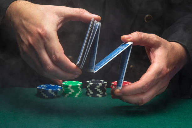 Dealer or croupier shuffles poker cards in a poker club against the background of a green table with chips. Concept of playing poker or gaming business Dealer or croupier shuffles poker cards in a poker club against the background of a green table with chips. Concept of playing poker or gaming business. dibs stock pictures, royalty-free photos & images