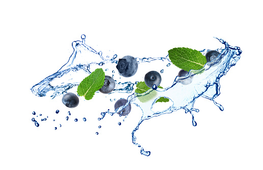 Fresh ripe blueberries, mint and splashing water on white background