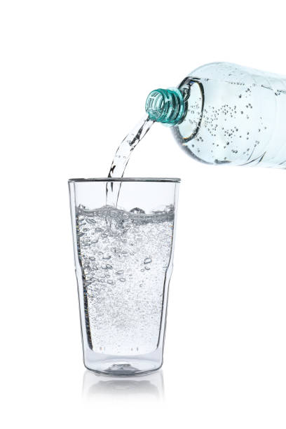istock Pouring soda water from bottle into glass on white background 1483377038