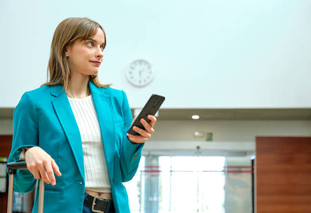 istock Young woman at train station with her smart phone in hand while waiting for her train 1483377589