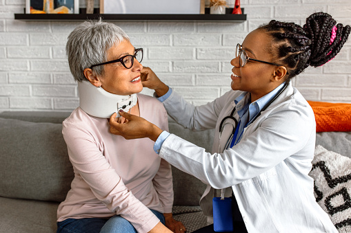 Recovering female patient with her doctor at home