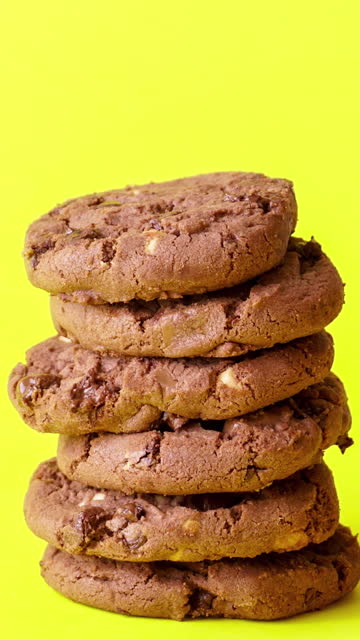 stacking of chocolate chip cookie on yelow background