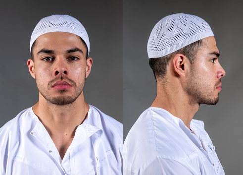 Young muslim man looking at the camera mugshot on gray background