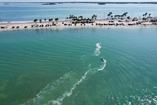 Drone photography of a  jet skiing at Honeymoon Island in Dunedin, Florida, with beautiful green waters from a drone view.