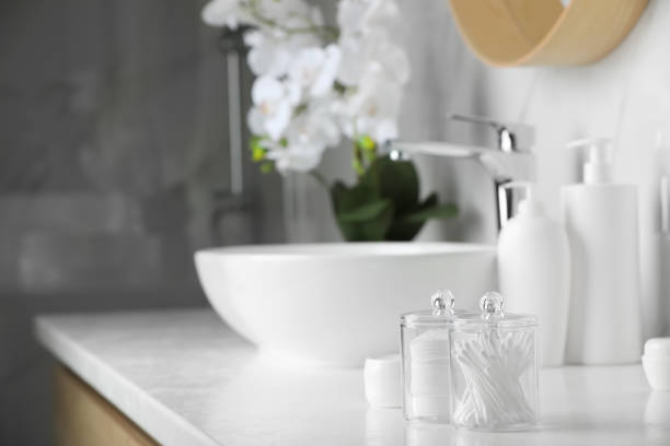 istock Containers with cotton swabs and pads on white countertop in bathroom. Space for text 1483390924