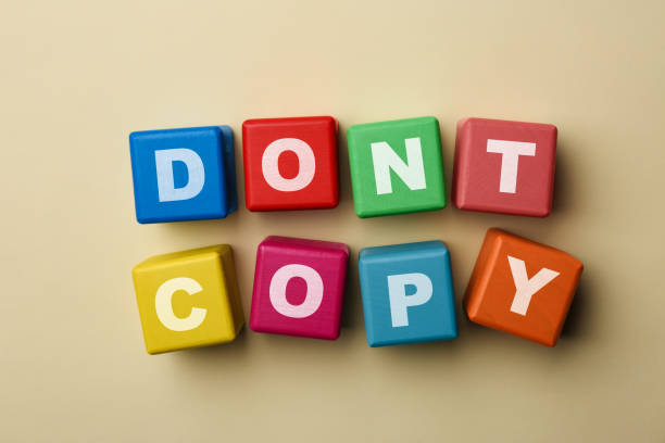 istock Colorful cubes with words Don't Copy on beige background, flat lay. Plagiarism concept 1483391164