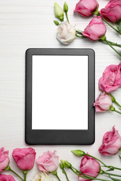 istock E-book reader with flowers on white wooden table, flat lay. Space for text 1483391295