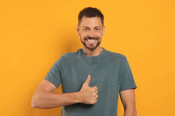 istock Man showing thumb up on orange background 1483392750