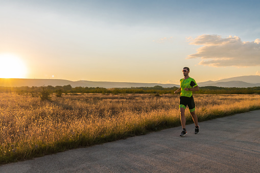 Triathlete in professional gear running early in the morning, preparing for a marathon, dedication to sport and readiness to take on the challenges of a marathon