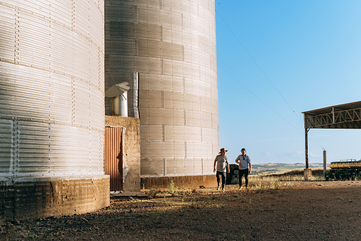 Farmers walking on grain silos