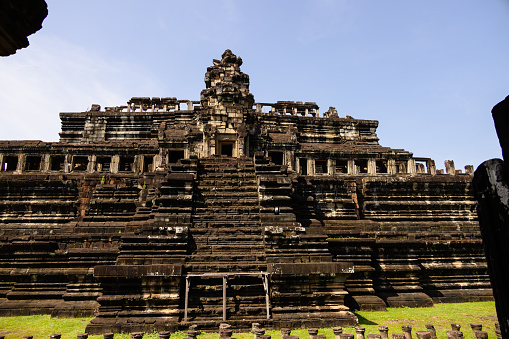 Angkor Vat, Cambodia - September 04, 2019: Towers and Faces at Bayon temple in Angkor Wat. Monk who has umbrella at Bayon Temple with Tourist woman.