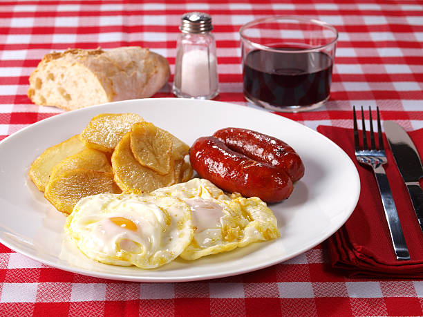 Fried eggs & potatoes with “chorizo” (red spicy sausage) stock photo