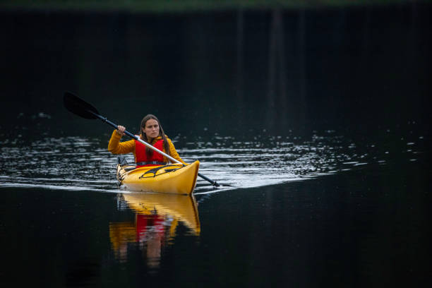 People and nature. Woman paddling in mountain lake. stock photo