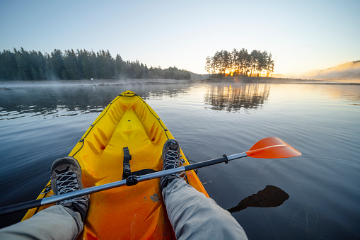 Paddling and eco tourism. Rowing in a calm water at sunrise. Connecting with nature.