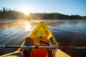 People and nature, POV. Kayaking in lake at sunrise.