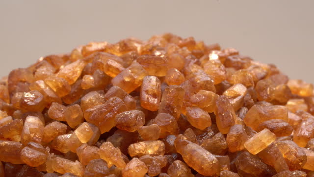 Closeup view rotation of brown sweet crystal caramel.