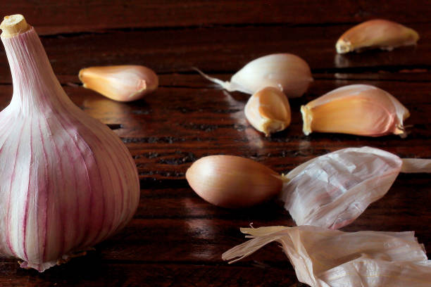 istock Organic garlic bulb isolated over rustic wooden kitchen table. Condiment harvested fresh from plantation. Closeup view 1483416868