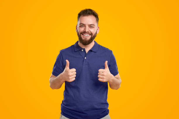 Happy man showing thumbs up in studio stock photo