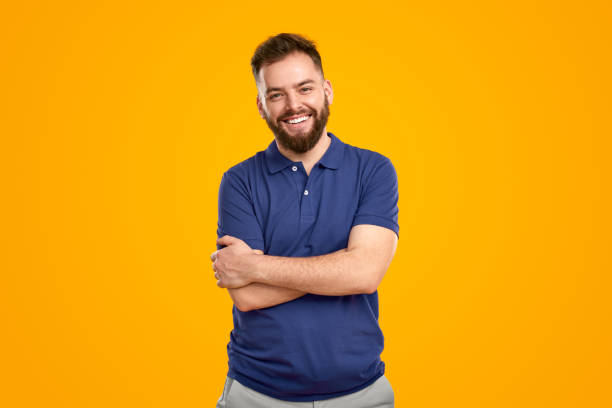 istock Positive young bearded man standing with folded arms and smiling 1483416880