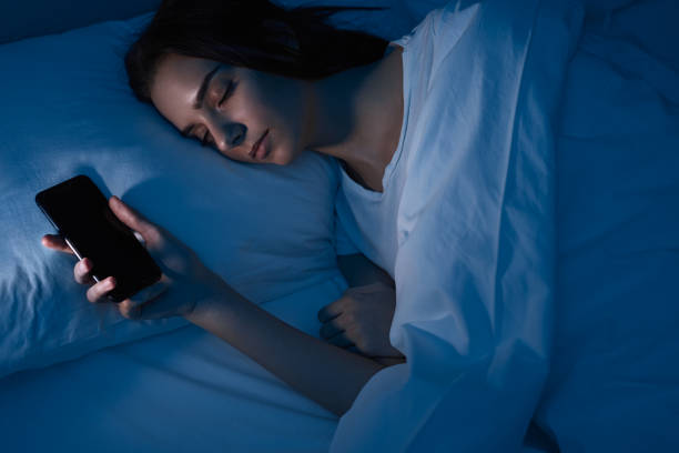 istock Woman sleeping with smartphone in bed 1483417002