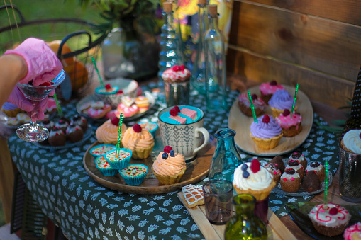 Colorful cupcakes and muffins on the table in the garden