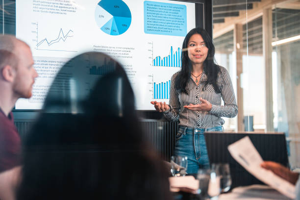 istock Serious Latin Female Using Screen to Present Company Stats 1483417618