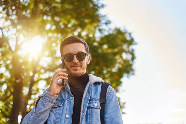istock A student walking through the city carrying a backpack and wearing sunglasses while using a smartphone, representing the modern urban lifestyle and reliance on technology for communication and exploration. 1483419919