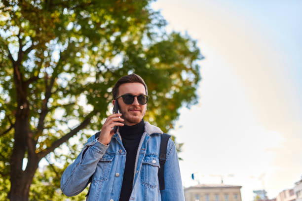 istock A student walking through the city carrying a backpack and wearing sunglasses while using a smartphone, representing the modern urban lifestyle and reliance on technology for communication and exploration. 1483420058