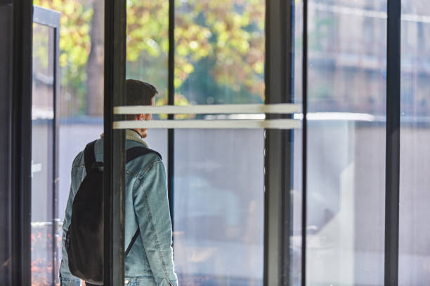 istock After finishing his work, a man steps out of his office while carrying a backpack and wearing wireless headphones, ready to unwind and enjoy the freedom of the urban environment, suggesting a modern approach to work and personal life. 1483420297
