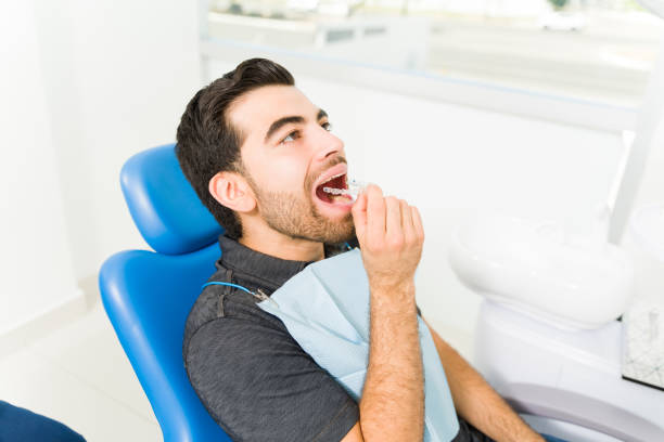 istock Attractive man patient at the dentist putting on invisible orthodontics 1483421827