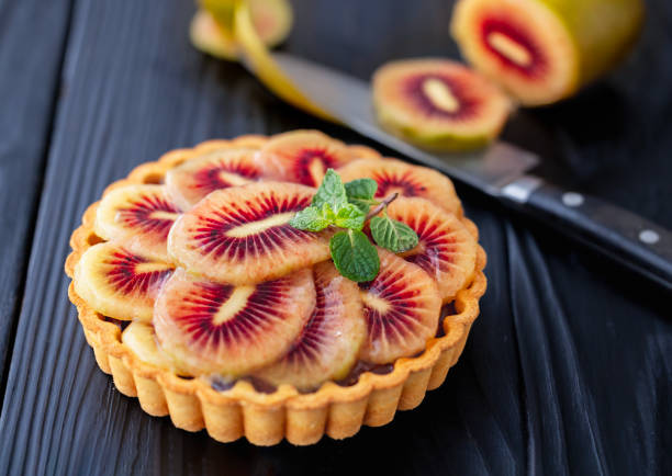 Red Kiwi and Chocolate Ganache Tart on a Black Wooden Table