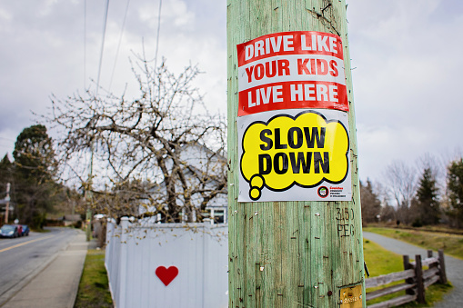 Chemainus, Canada - April 19, 2023. Caution signs appear on a telephone pole adjacent to the Trans-Canada Trail in Chemainus to warn drivers to be aware that children are present in the neighborhood.